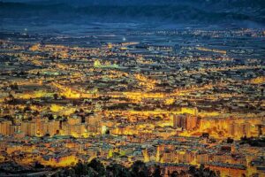 Ciudad al atardecer en tonos dorados y con fondo azul