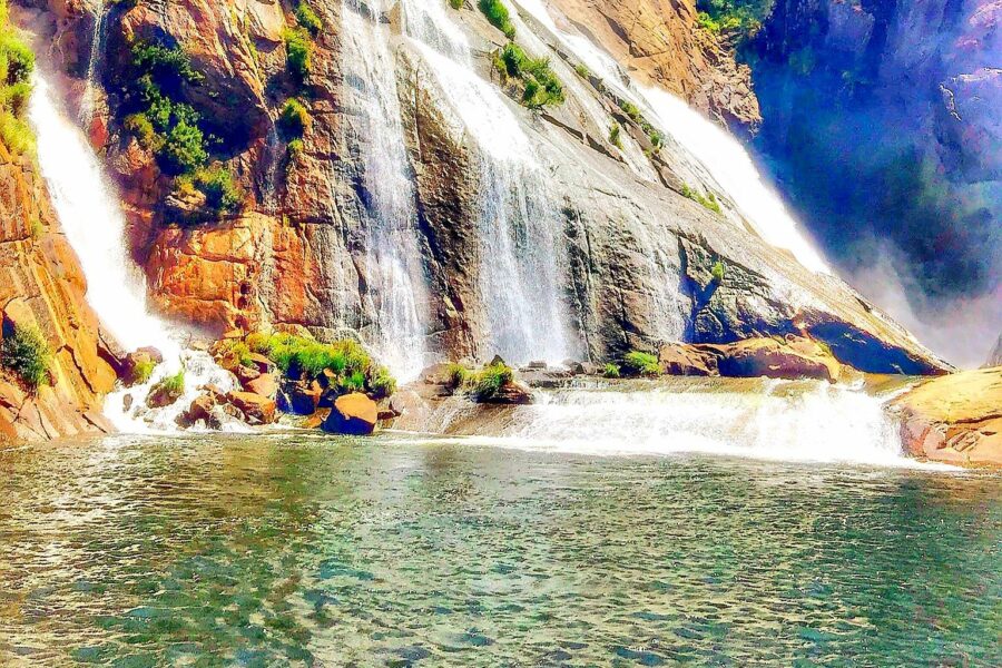 Cascada cae sobre rocas y desemboca en el mar