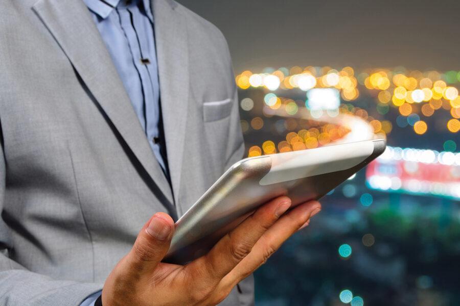 Handsome Business male in the city using his Smart Tablet PC with Bokeh Background
