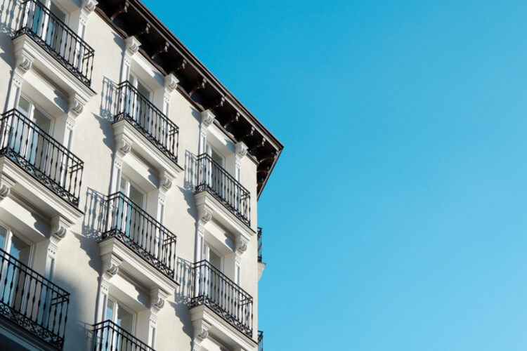 Corner of classical white building with windows and balconies downtown of Madrid, Spain