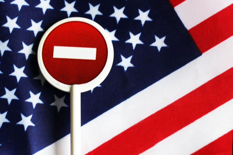 una señal de prohibido sobre la bandera de Estados Unidos